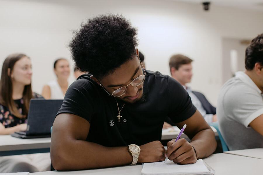 PBA student takes notes in class.